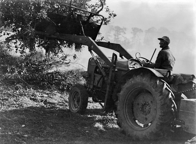 361073 Afbeelding van een boer met een tractor.